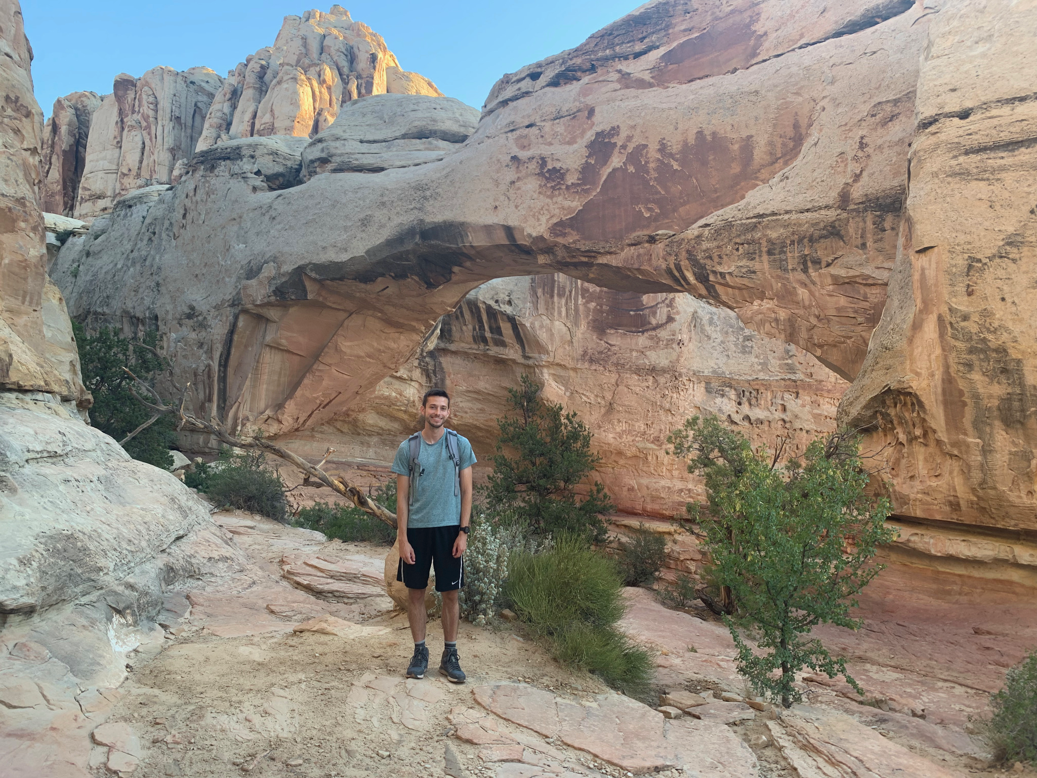 John at Hickman Bridge, with a heart in the rock wall behind